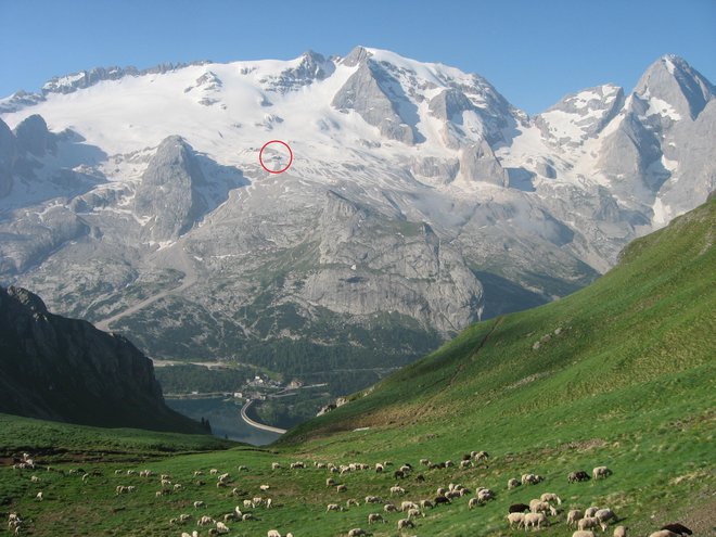 Marmolada, s 3343 metri najvišji vrh Dolomitov. V krogu sta vidni koča Pian dei Fiacconi in zgornja postaja žičnice. FOTO: Viki Grošelj