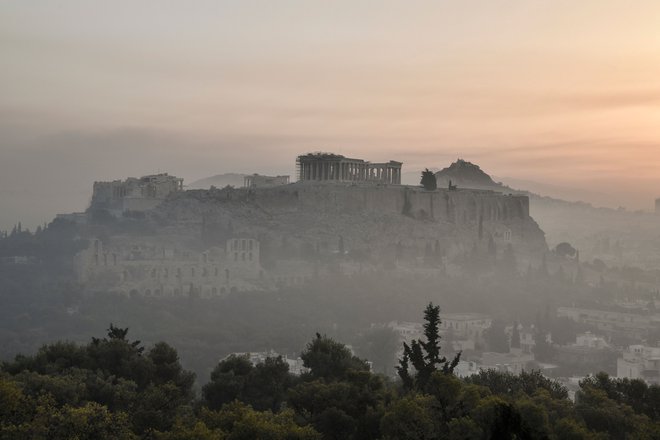 Dim je prekril središče Aten, gasilci pa upajo, da bodo gozdni požar danes spravili pod nadzor. Na fotografiji atenska akropola, obdana z dimom. FOTO: Louisa Gouliamaki/AFP