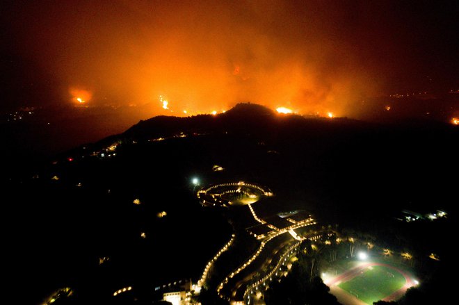 Grški gasilci se v rekordnem vročinskem valu borijo z dvema velikima požaroma, na fotografiji je starodavna Olimpija v zahodni Grčiji. FOTO: Eurokinissi/AFP