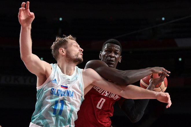 Bonga v boju za žogo z Jako Blažičem med obračunom četrtfinala olimpijskih iger. Slovenija je zmagala s 94:70. FOTO: Aris Messinis/AFP