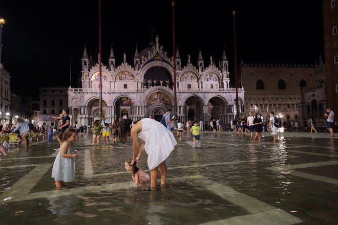 People walk in a flooded St. Mark&#39;s Square during an exceptional high water in Venice, Italy August 8, 2021. Picture taken August 8, 2021. REUTERS/Manuel Silvestri Foto Manuel Silvestri Reuters