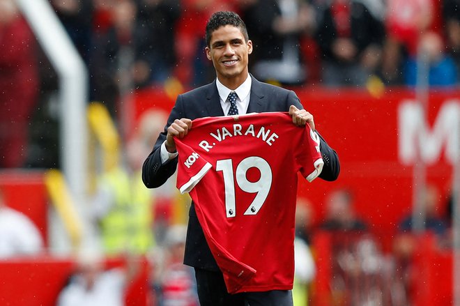 Varane je z novim dresom v rokah pozdravil navijače pred zadnjo ligaško tekmo na Old Traffordu. Foto Adrian Dennis/Afp