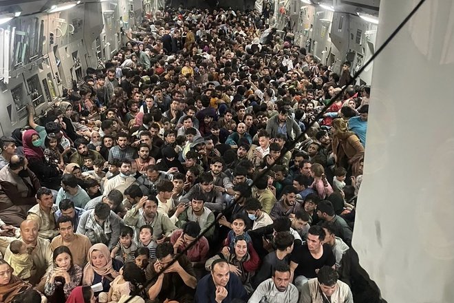 Ameriški vojaški pilot je na kabulskem letališču v tovorno letalo, ki naj bi sprejelo največ 150 ljudi, natlačil več kot 600 potnikov. FOTO: Kap. Chris Herbert/zračne sile ZDA/AFP