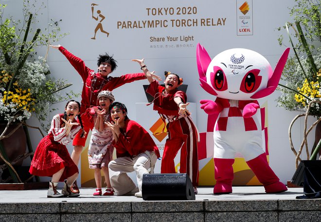 Skupina Foorin je z maskoto iger Someityjem zaplesala med slovesno združitvijo paralimpijskih plamenic v Tokiu. FOTO: Issei Kato Reuters