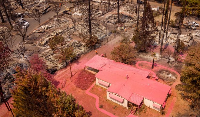 Pogled iz zraka prikazuje dom, pokrit z barvasto snovjo, ki je ščitila hišo pred ognjem. Več deset nepremičnin, okoli hiše pa je bilo požganih do tal v Creeksideu, potem ko je požar Cache zajel območje v kalifornijskem Clearlakeu. FOTO: Josh Edelson/Afp<br />
&nbsp;
