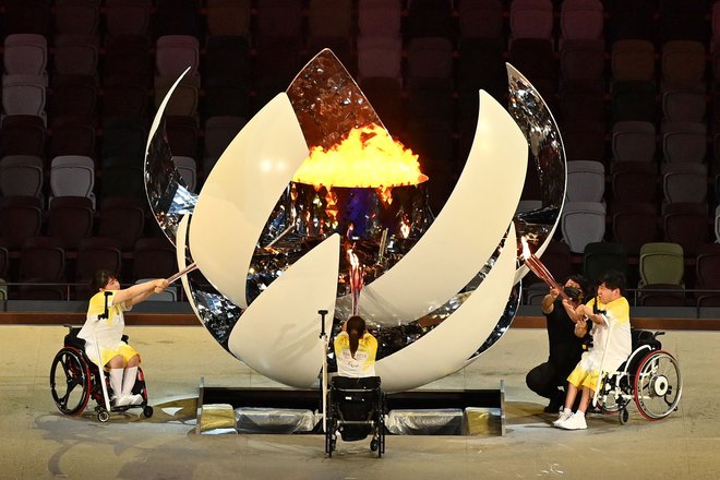 Na stadionu so prižgali ogenj trije paraolimpijci, in igre so se začele. FOTO: Charly Triballeau/AFP