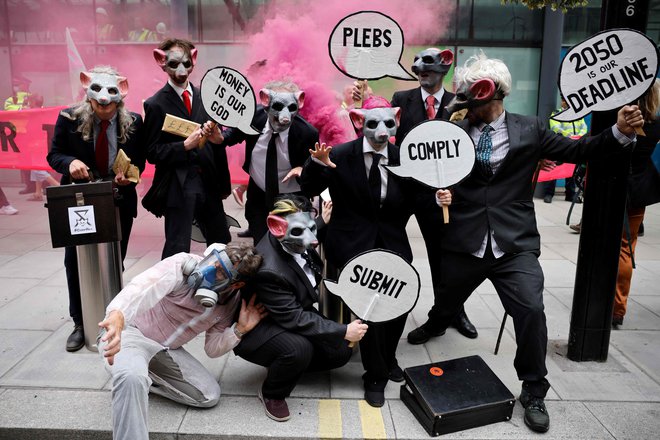 Podnebni aktivisti iz skupine Extinction Rebellion na protestu nosijo maske podgan, ko protestirajo pred stavbo oddelka za poslovanje, energijo in industrijsko strategijo (BEIS) v središču Londona FOTO: Tolga Akmen/Afp