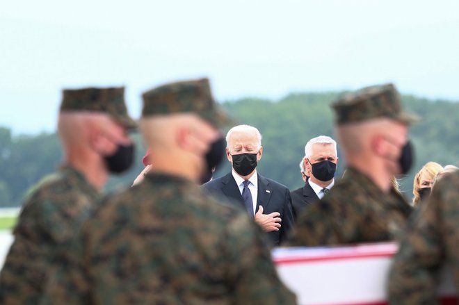 Ameriški predsednik Joe Biden s prvo damo spremlja transport trupel ameriških vojakov, ubitih v četrtkovem terorističnem napadu na kabulsko letališče. FOTO: Tom Brenner/Reuters