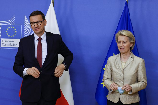 EU Commission President Ursula von der Leyen (R) welcomes Poland's Prime Minister Mateusz Morawiecki (L) as he arrives for a bilateral meeting in Brussels on July 13, 2021. (Photo by PASCAL ROSSIGNOL / POOL / AFP)