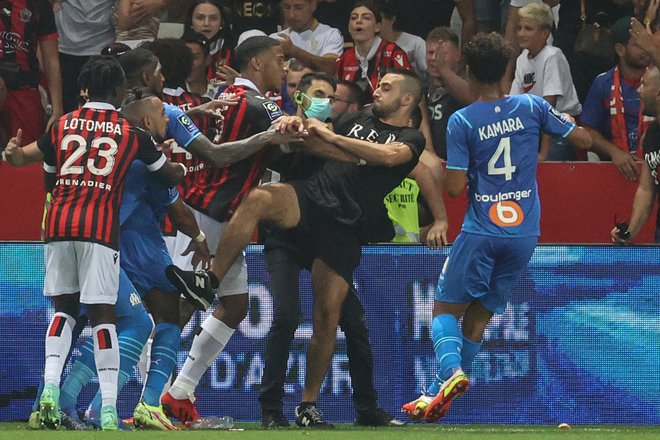 Payet (spodaj levo v modrem dresu) se je moral braniti pred jeznimi navijači Nice. FOTO: Valery Hache/AFP