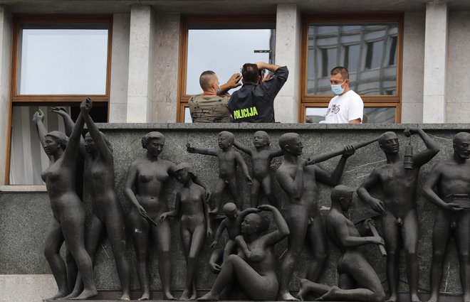 Policisti pregledujejo škodo na stavbi državnega zbora, po včerajčnijh protestih. FOTO: Matej Družnik/Delo