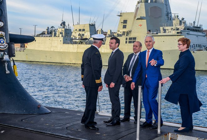 Francoski predsednik Emmanuel Macron in nekdanji avstralski premier Malcolm Turnbull (drugi z desne) stojita na krovu podmornice avstralske mornarice med Francozovim obiskom v Sidneyju leta 2018. FOTO: Brendan Esposito/AFP