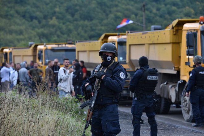 Specialne enote kosovske policije nadzirajo srbske protestnike, ki so s tovornjaki onemogočili dostop do mejnega prehoda med Kosovom in Srbijo.&nbsp; Foto Laura Hasani Reuters