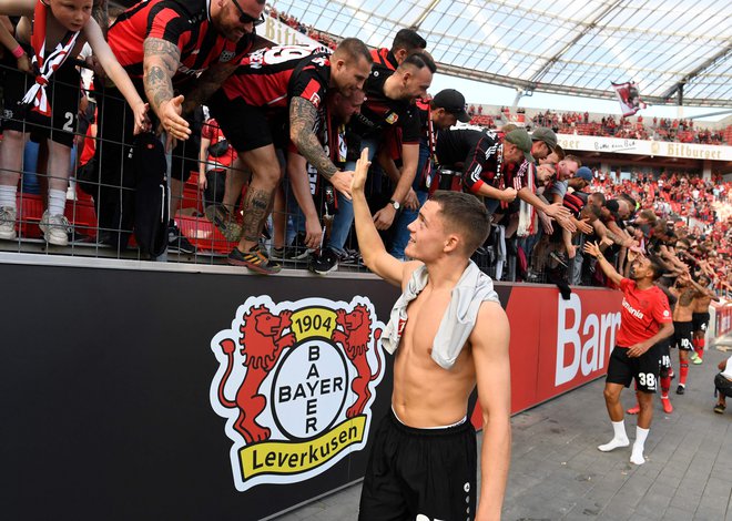 Florian Wirtz, na fotografiji pozdravlja navijače Bayerja iz Leverkusna, je novi nemški nogometni up, strelsko se je že dokazal. FOTO: Roberto Pfeil/AFP