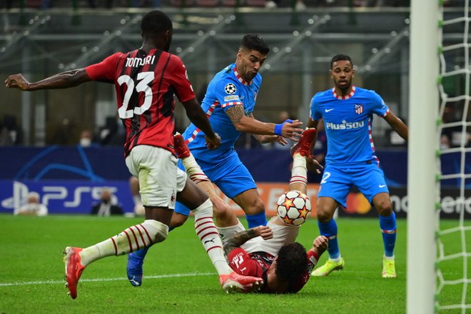 Luis Suarez se bori z branilci Milana. Na nesrečnem prizorišču za Atletico je Urugvajec na koncu poskrbel za sladko zmago. FOTO: Miguel Medina/AFP