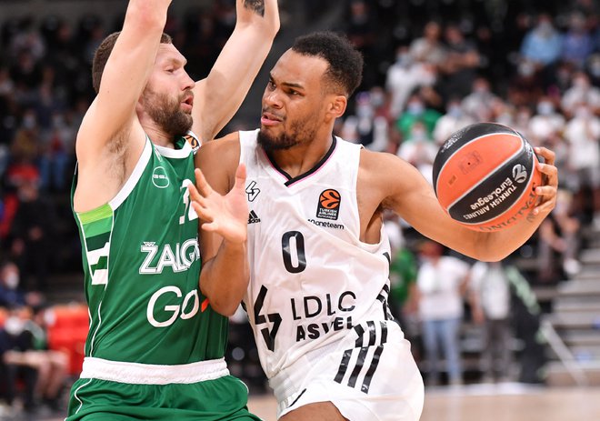 Elie Okobo (z žogo) med prodorom&nbsp;ob Janisu Strelnieksu na obračunu Asvela in Žalgirisa&nbsp;v lyonem Villeurbannu. FOTO: Philippe Desmazes/AFP