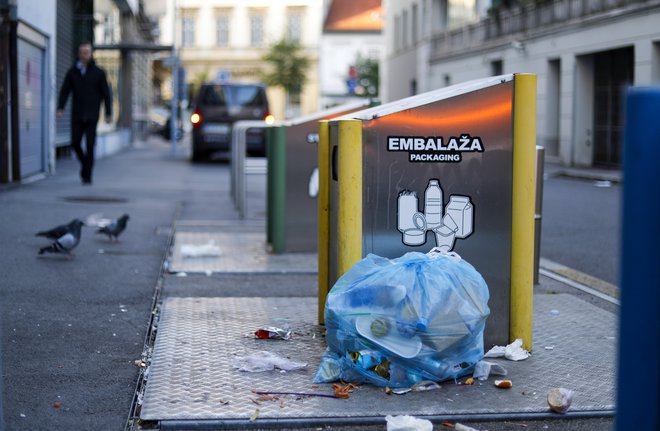 Pisane vreče s smetmi ob potopnih smetnjakih mestu zagotovo niso v ponos. FOTO: Matej Družnik/Delo