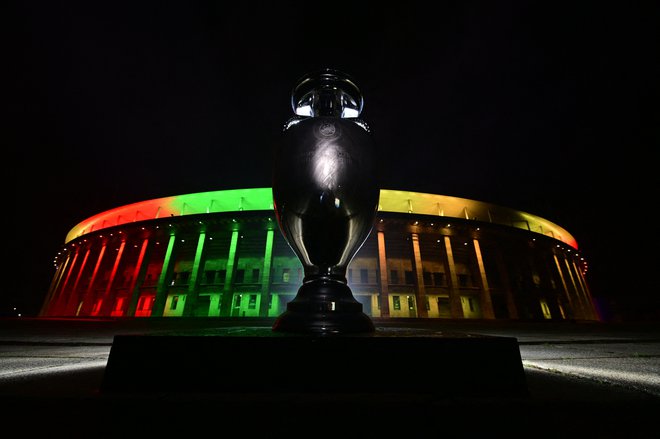 Berlinski olimpijski štadion in pokal, ki ga je na letošnjem prvem panevropskem prvenstvu v Londonu osvojila Italija. FOTO: John Macdougall/AFP