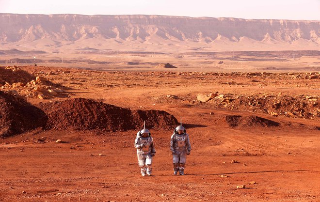 Astronavta iz Evrope in Izraela hodita v vesoljskih oblekah med pripravami za misijo na Mars v izraelski južni puščavi Negev, ki simulira pogoje v marsovem kraterju Ramon. Šest astronavtov iz Portugalske, Španije, Nemčije, Nizozemske, Avstrije in Izraela bo en mesec (4. do 31. oktober) odrezano od sveta. Svoj habitat bodo lahko zapustili le v vesoljskih oblekah, kot da bi bili na Marsu. FOTO: Jack Guez/Afp<br />
&nbsp;