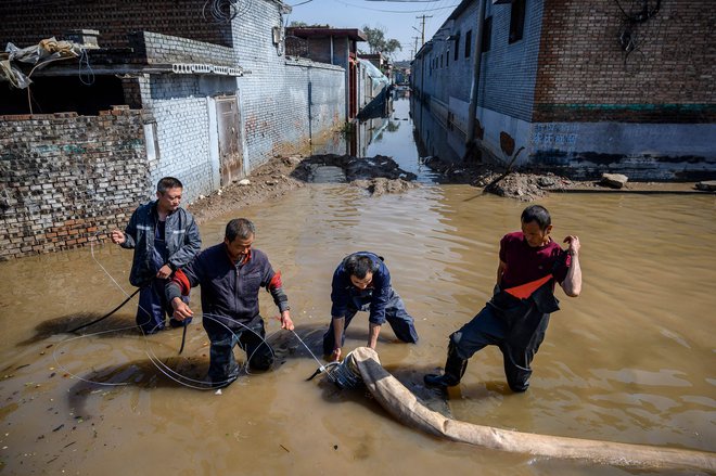 V kitajski provinci Shanxi, ki je glavna kitajska premogovniška provinca, so poplave prizadele skoraj dva milijona ljudi, po navedbah lokalnih medijev so morali evakuirati 120.000 prebivalcev. FOTO: AFP