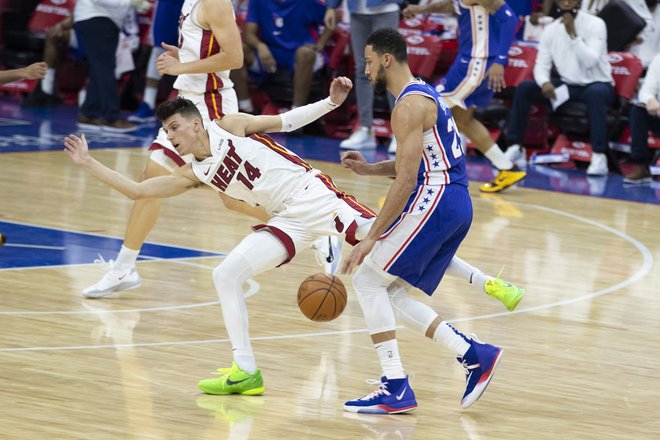 Ben Simmons (desno) prodira ob Tylerju Herru na tekmi z Miami Heat. FOTO: Mitchell Leff/AFP