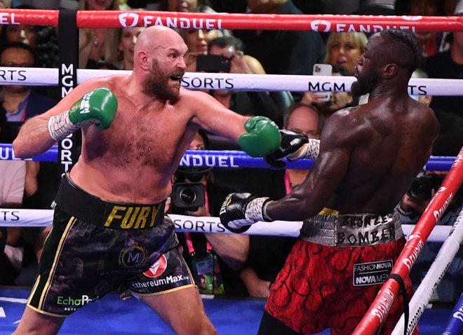 Tyson Fury in Deontay Wilder med sedmo rundo spektakularnega obračuna v Las Vegasu. FOTO: Robyn Beck/AFP
