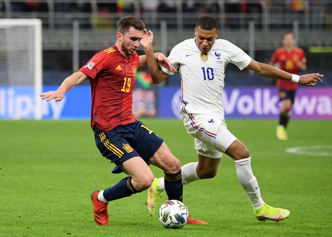 Kylian Mbappe (desno) med finalnim obračunom z nekdanjim mladim francoskim reprezentantom Aymericom Laportom, ki zdaj brani barve Španije. FOTO: Alberto Lingria/Reuters
