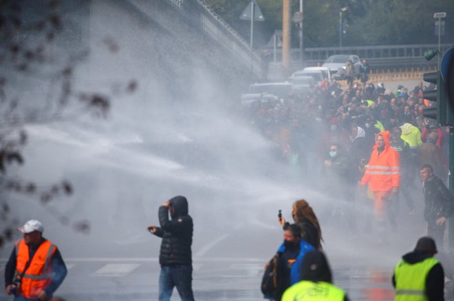 Demonstrante, ki so v Trst prišli tudi od drugod, razganjajo na silo, saj ovirajo delovanje pristanišča. FOTO: Borut Zivulovic/Reuters
