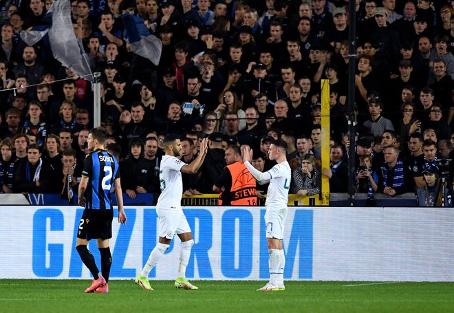 Phil Foden (desno) in Riyad Mahrez proslavljata pred navijači Bruggea. FOTO: John Thys/AFP
