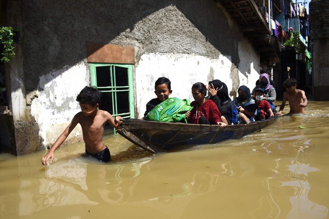 Družina se je bila primorana evakuirati iz poplavljenega doma po močnem dežju v indonezijskem mestu Bandung. FOTO: Timur Matahari/AFP

&nbsp;
