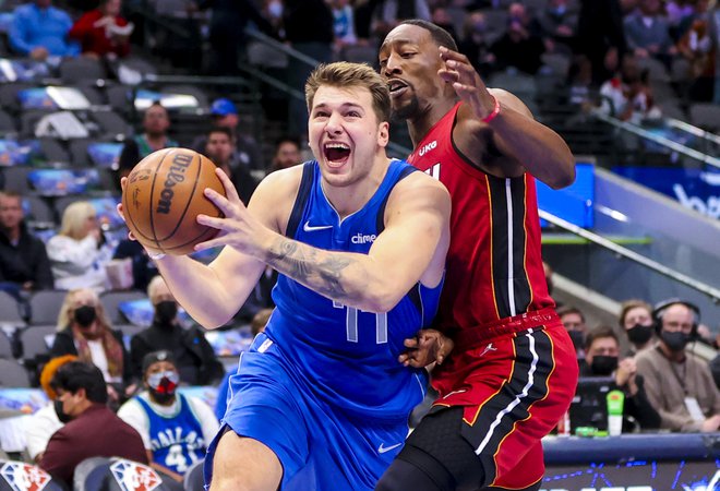 Luka Dončić prodira ob Bamu Adebayu, ki je s soigralci spisal zgodovino na tekmi v Dallasu. FOTO: Kevin Jairaj/USA Today Sports
