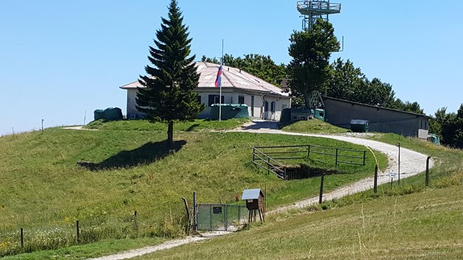 Ob vojaškem objektu na Trdinovem vrhu še vedno plapola slovenska zastava, čeprav je vojašnica po arbitražni razsodbi na ozemlju sosednje Hrvaške.&nbsp; FOTO: Bojan Rajšek/Delo
