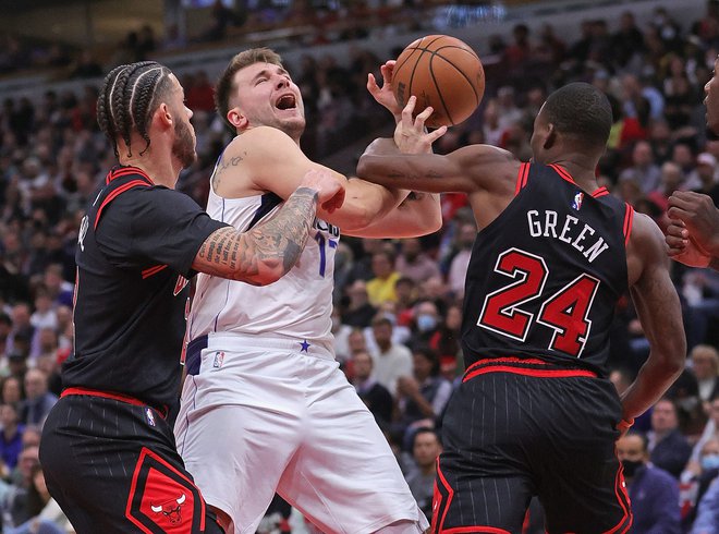 Luka Dončić&nbsp;prodira ob Javonteju&nbsp;Greenu (št. 24)&nbsp;in Lonzu Ballu, ki je bil za Dallas usoden s skoraj brezhibnim&nbsp;metom z razdalje. FOTO: Jonathan Daniel/AFP
