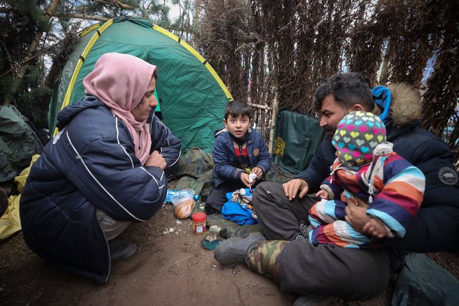 Migrantska družina se je zatekla na območje ob belorusko-poljski meji. FOTO:&nbsp;Leonid Ščeglov/AFP
