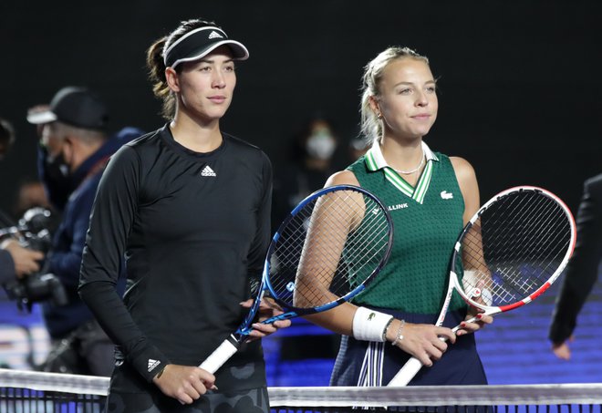 Španka Garbine Muguruza (levo) je končala niz dvanajstih zmag Estonke Anette Kontaveite, a obe teniški igralki sta se uvrstili v polfinale zaključnega turnirja WTA. FOTO: Henry Romero/Reuters
