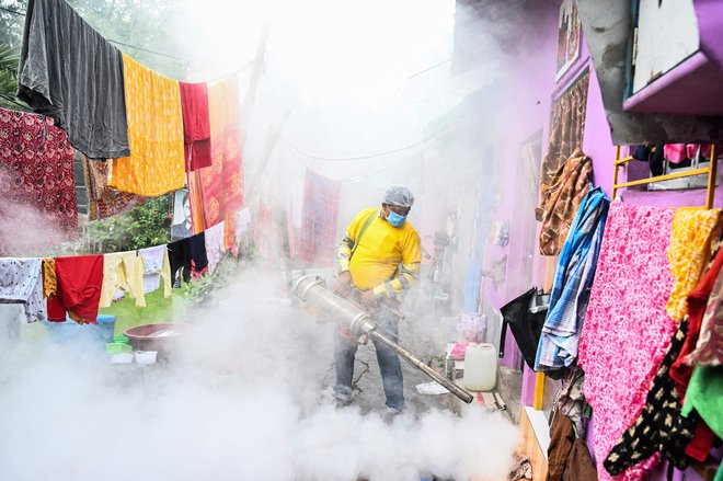Občinski delavec zaplinjuje revnejša območja v Kolkati kot preventivo proti boleznim, ki jih povzročajo komarji. FOTO: Dibyangshu Sarkar/Afp

&nbsp;
