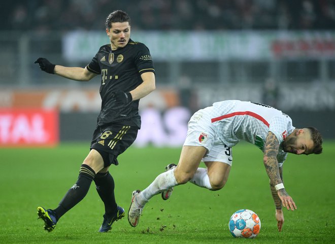 Marcel Sabitzer (levo)&nbsp;in Niklas Dorsch sta se spopadla za žogo na bavarskem obračunu v Augsburgu. FOTO: Christof Stache/AFP
