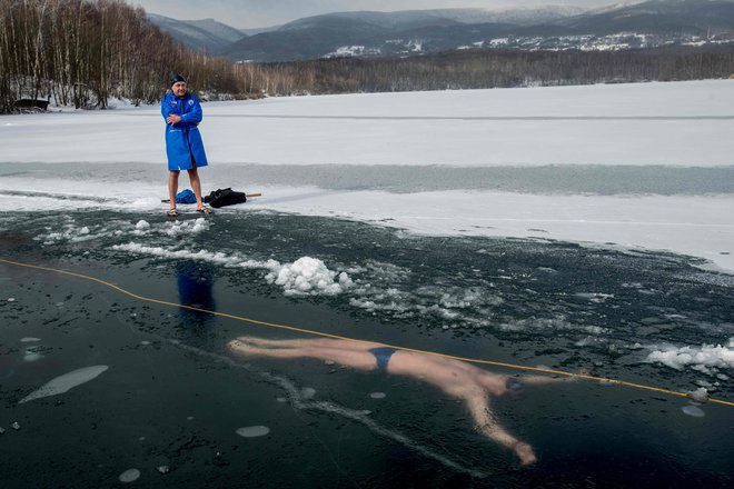 Češki potapljač David Vencl, posnet med plavanjem pod ledom februarja letos, ko se je pripravljal na 80-metrsko plavanje pod ledom. Foto Michal Cizek/AFP)
