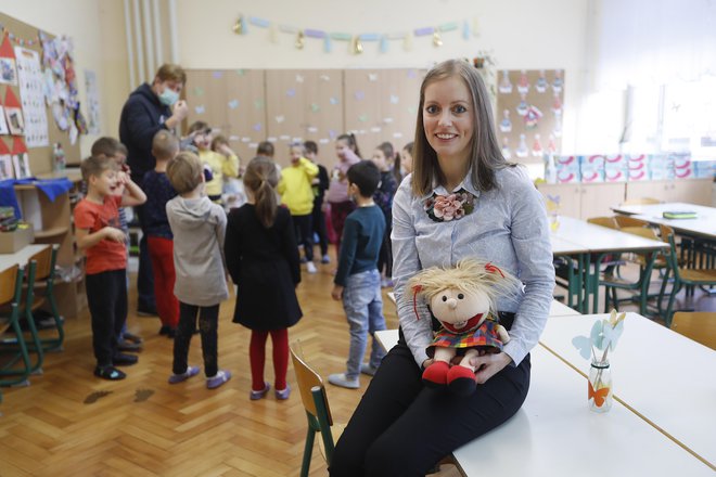 Otroci učiteljico Mojco Novak naravnost obožujejo, prav tako njeno pomočnico, lutko Zoe. Obiskali smo jih, še preden je bila tudi za učence obvezna maska v razredu. FOTO: Leon Vidic/Delo
