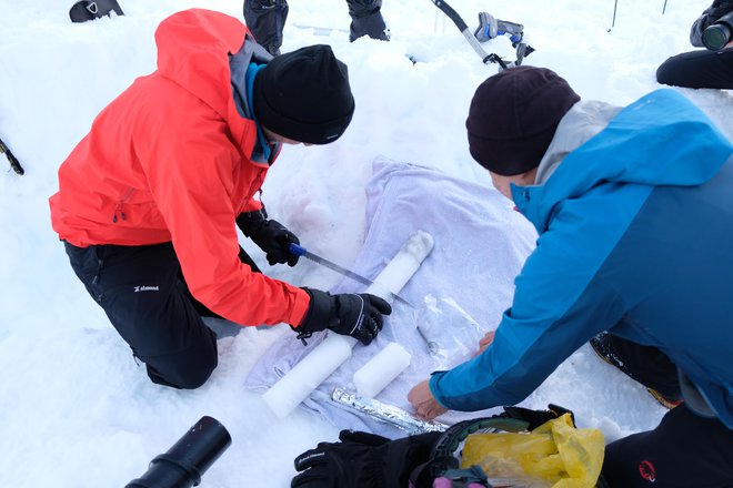 Testni preizkus novega ročnega lednega vrtalnika za odvzem globinskih vzorcev na snežišču v Vratih pod Triglavsko severno steno. FOTO: Andrej Štremfelj
