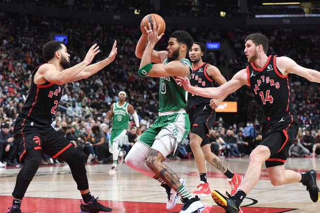 Jayson Tatum (z žogo) prodira pod koš ob Fredu VanVleetu in&nbsp;Sviju Mykhailiuku (št. 14) v drugem polčasu tekme v dvorani Scotiabank Arena. FOTO: Dan Hamilton/USA&nbsp;Today Sports
