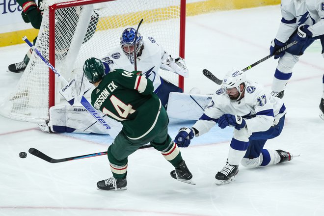 Joel Eriksson Ek (v zelenem dresu) poskuša zadeti mimo Andreja Vasiljevskega v vratih Tampe&nbsp;v dvorani Xcel Energy Center v St. Paulu. FOTO: David Berding/USA&nbsp;Today Sports
