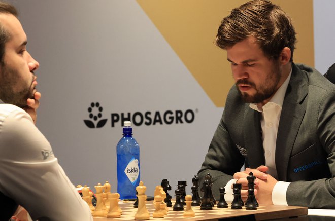 Magnus Carlsen (desno) in njegov ruski tekmec&nbsp;med peto partijo v Dubaju. FOTO: Giuseppe Cacace/AFP
