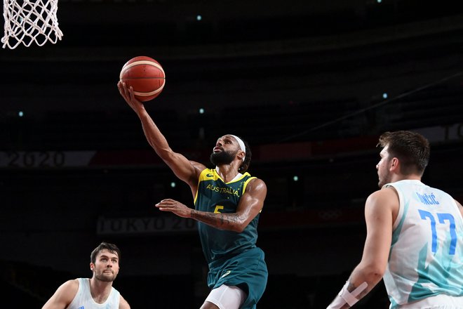 Patty Mills (z žogo) je bil v Saitami nerešljiva uganka za slovenske košarkarje na čelu z enim najboljših posameznikov turnirja Luko Dončićem. FOTO: Aris Messinis/AFP
