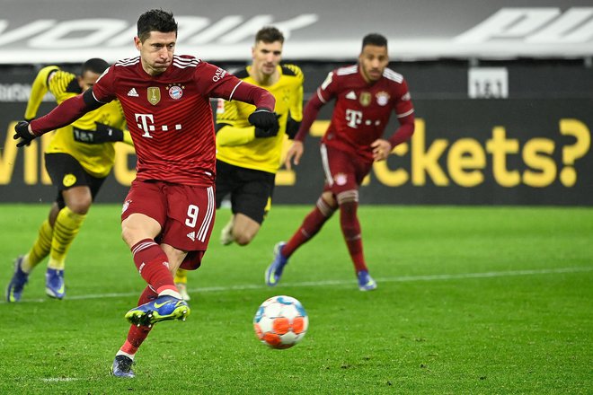 Robert Lewandowski je v 77. minuti odločil nemški derbi z uspešno izvedeno enajstmetrovko. FOTO: Ina Fassbender/AFP
