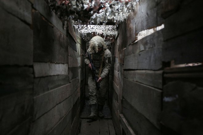 Ukrajinski vojak v rovu na bojni črti s separatisti v doneški regiji. FOTO: Anatolij Stepanov/AFP
