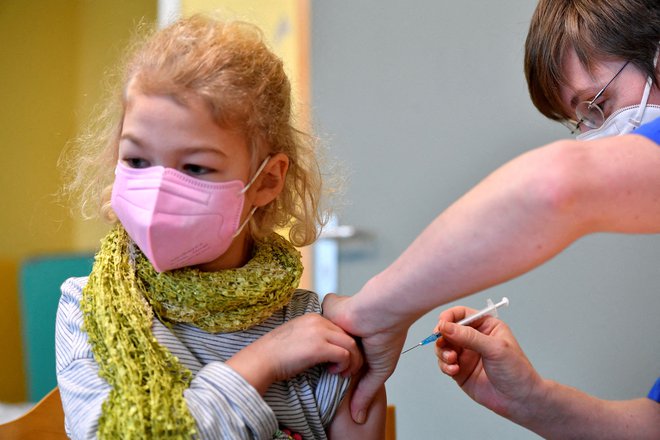 Sedemletnica na cepljenju v Nemčiji. FOTO: Matthias Rietschel/ Reuters
