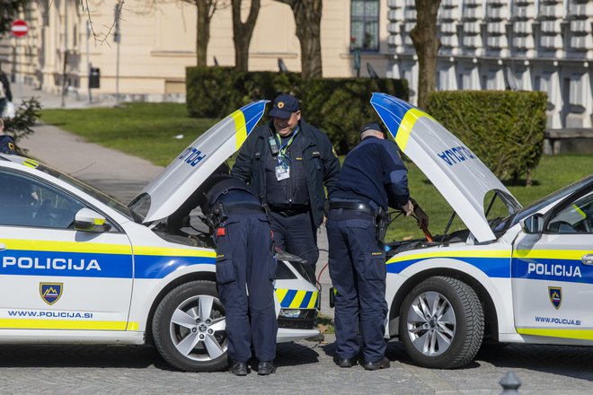 Policisti popravljajo avto na ulici v ljubljani 10. marca 2021. FOTO: Voranc Vogel/Delo
