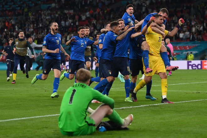 Nogometni azzurri z vratarjem Gianluigijem Donnarummo, desno, so bili po koncu finala eura 2020 v zmagovitem deliriju, angleški trije levi na tleh. FOTO: Laurence Griffiths/AFP
