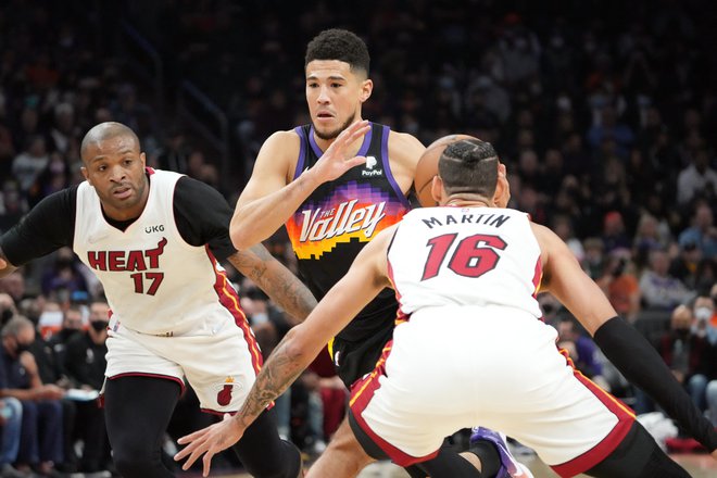 Devin Booker prodira ob P.J. Tuckerju in Calebu Martinu v domači dvorani Footprint Center. FOTO: Joe Camporeale/USA TODAY Sports
